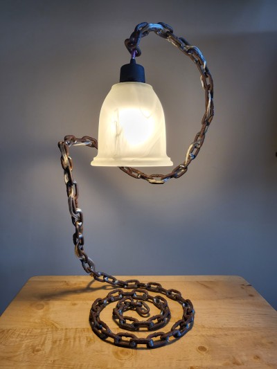 A lamp with a metal chain stand